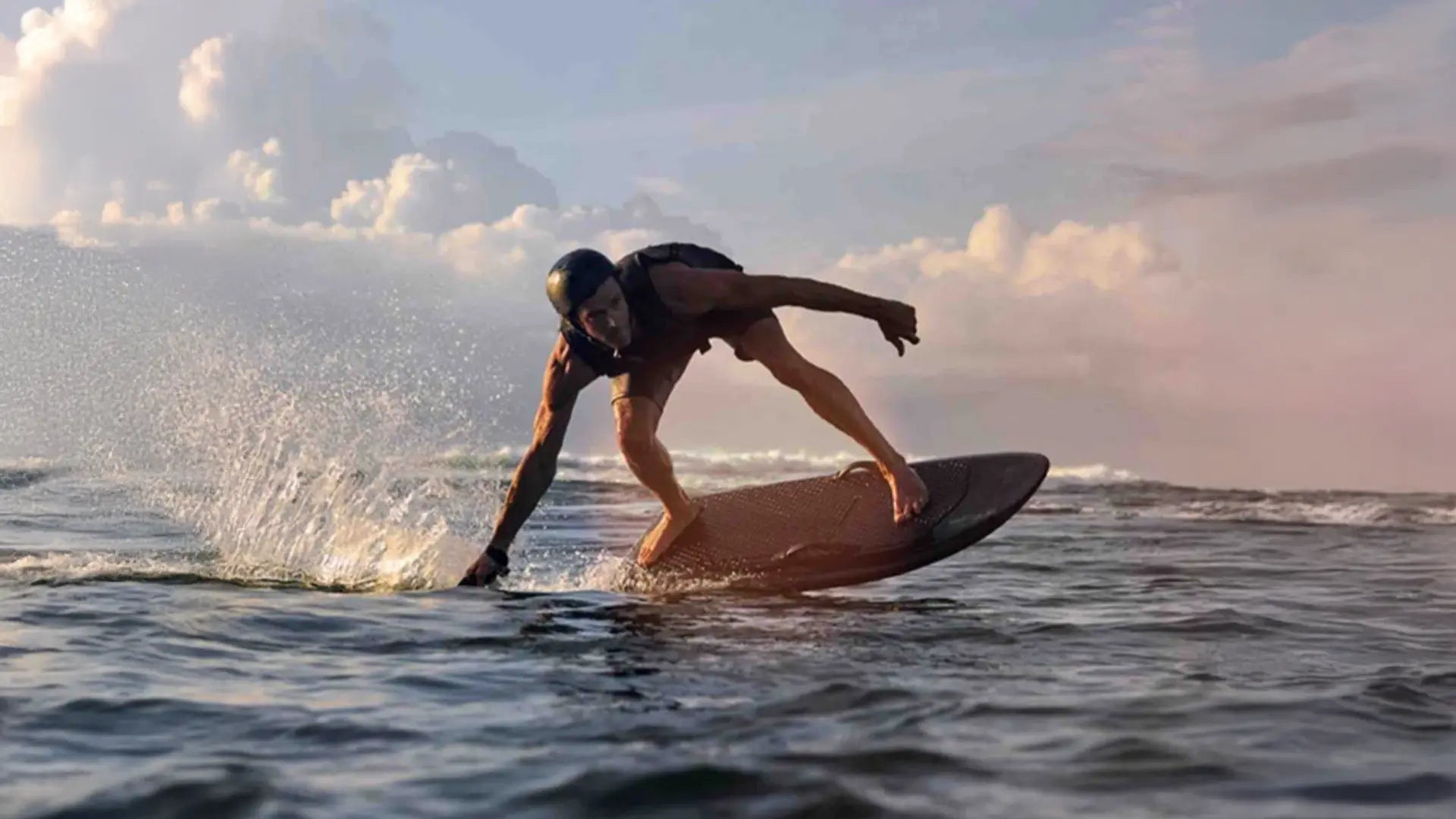 A man rides his Fliteboard round a steep bend on the sea.