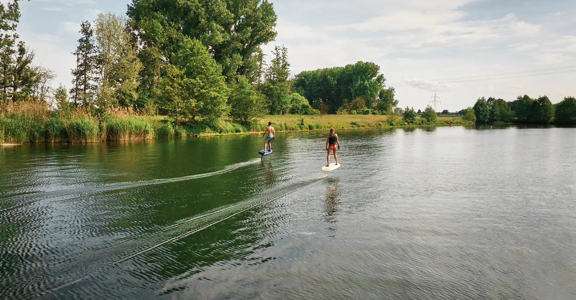 Two people efoiling on a fliteboard on a river in Germany.