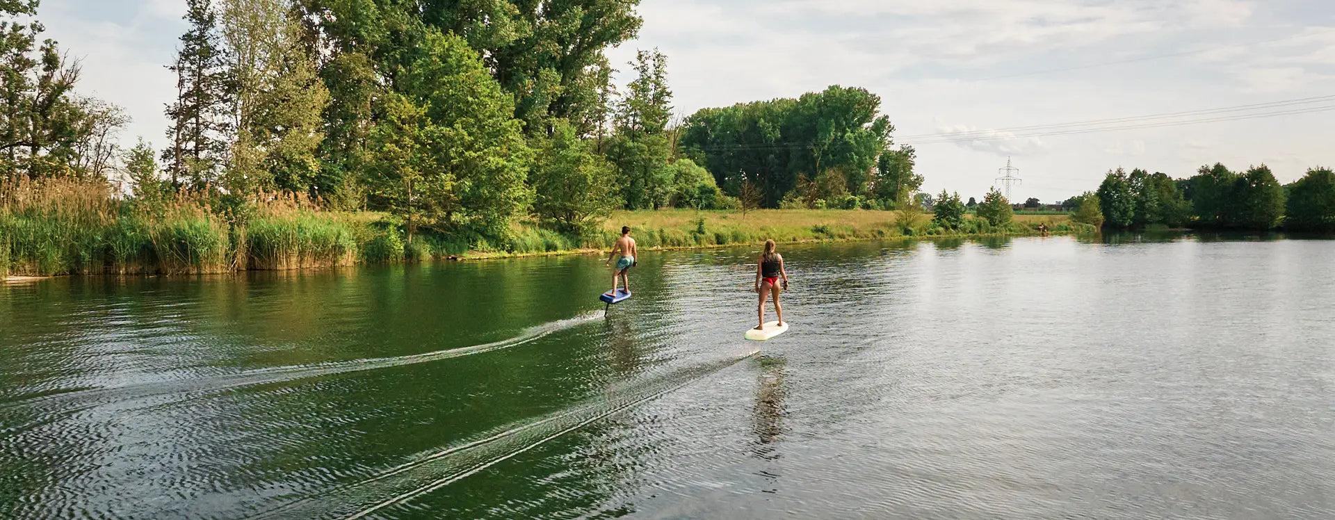 Two people efoiling on a fliteboard on a river in Germany.