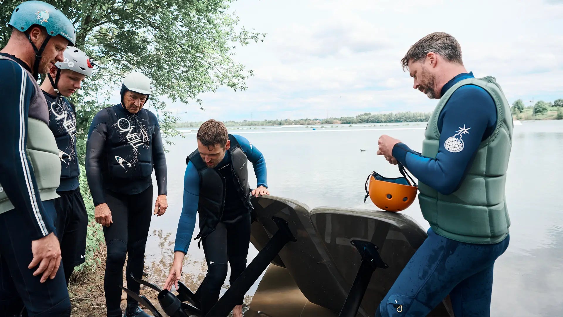 Group of people preparing for an efoil Session by a lake.
