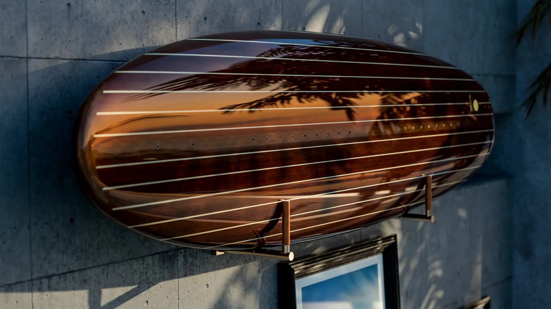 A Lind surfboard with a wooden look hangs on a stand on the wall and is illuminated by the sun.