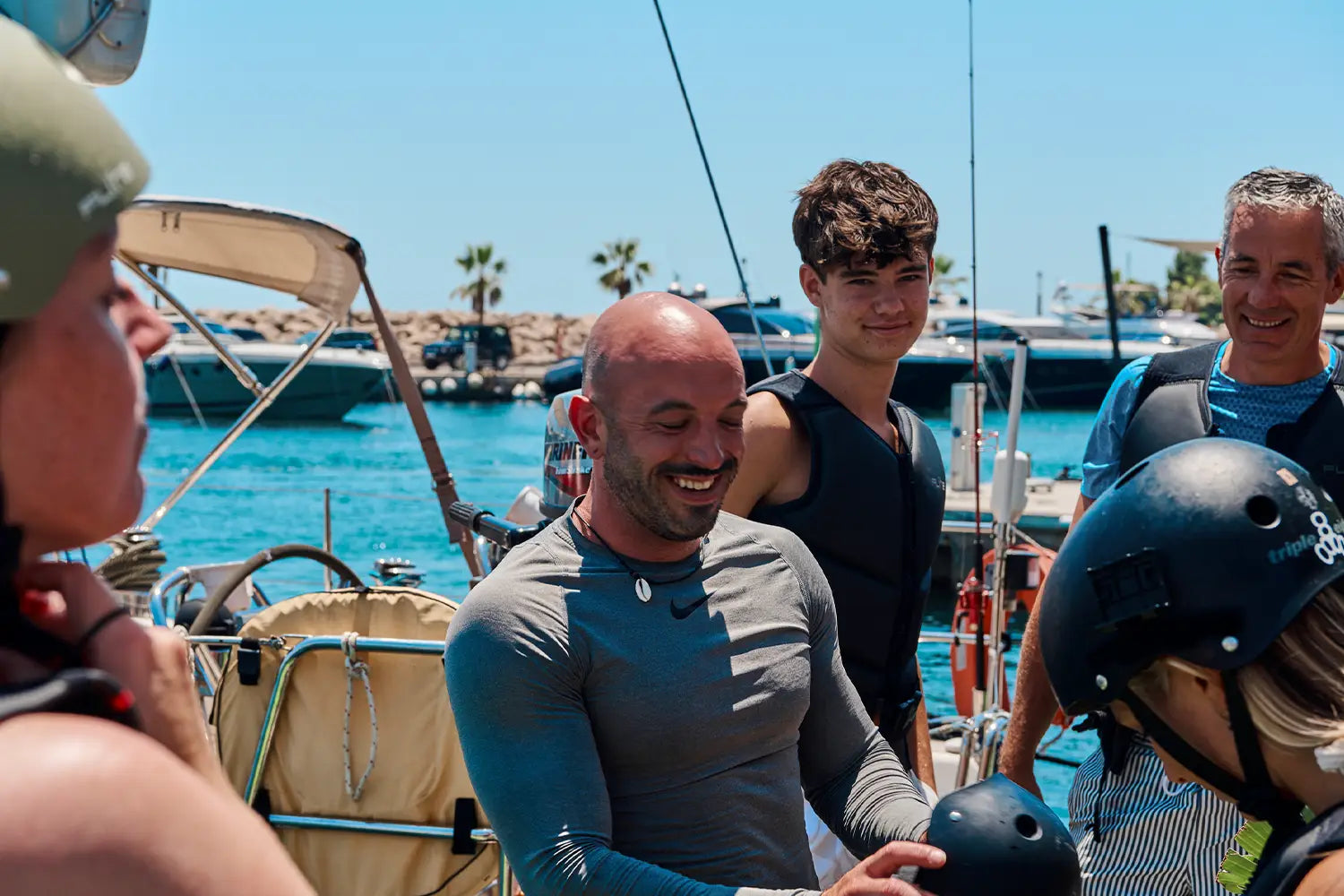 An Efoil-Instructor and some customers are smiling and preparing themself vor an Fliteboard session in Mallorca.