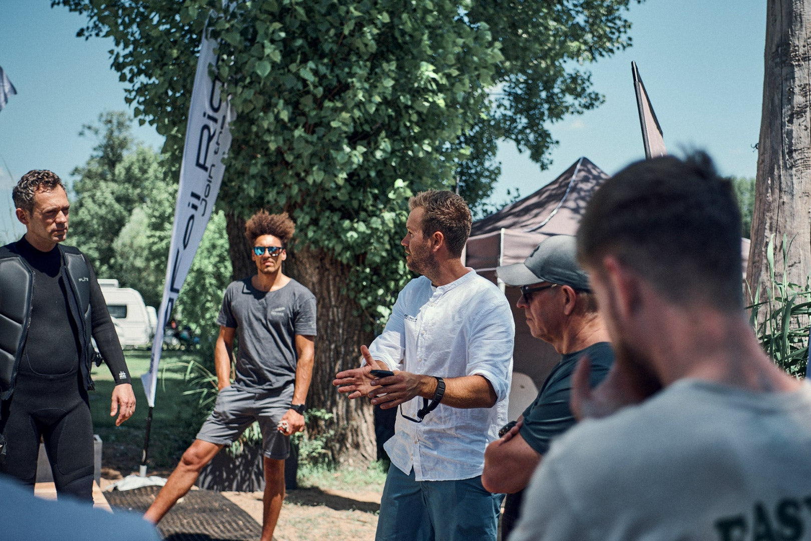 An eFoil Riders Surf instructor gives five people a briefing on how to use the Fliteboards.