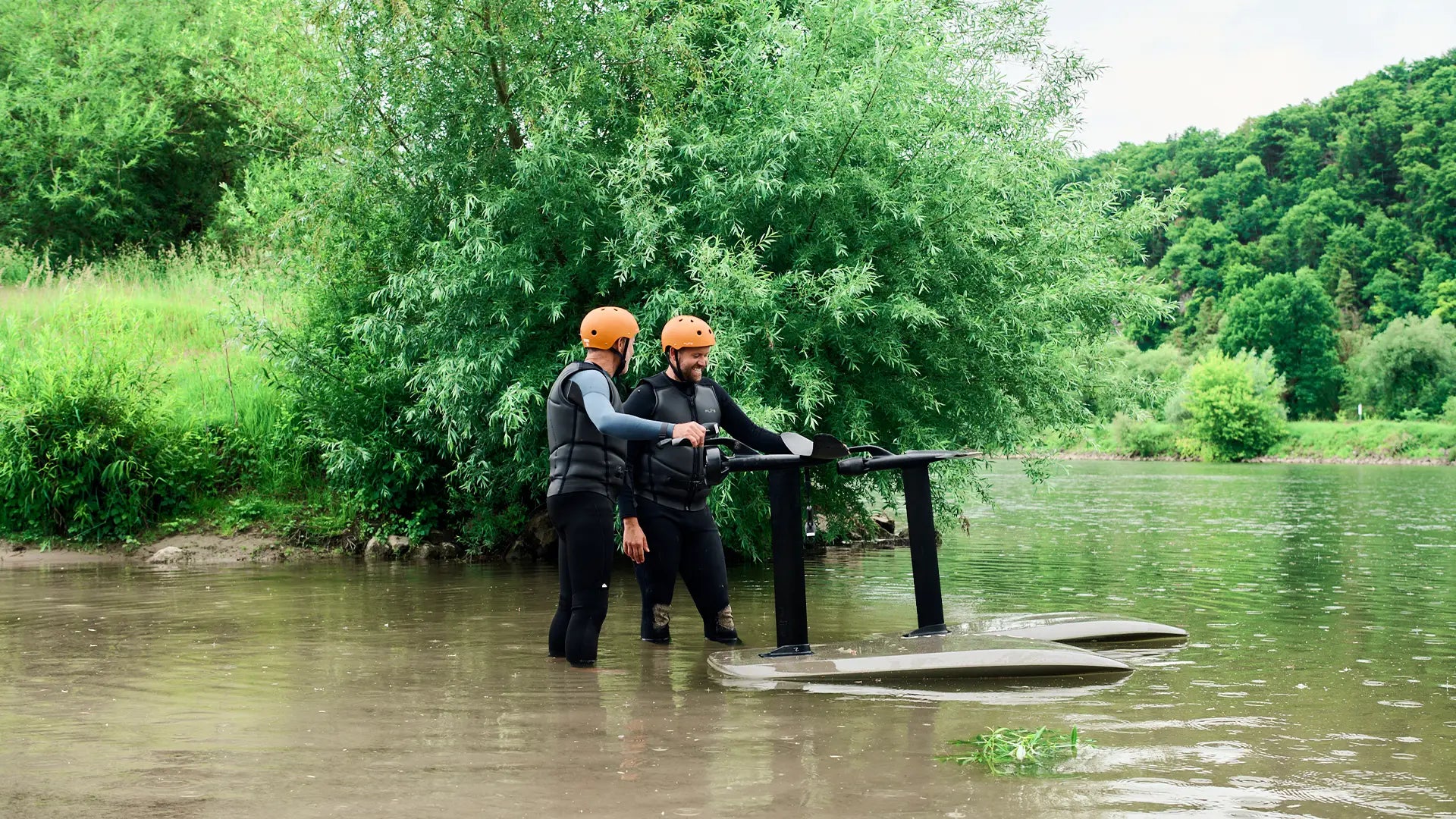 Two people standing next to their fliteboards in a river in Germany.