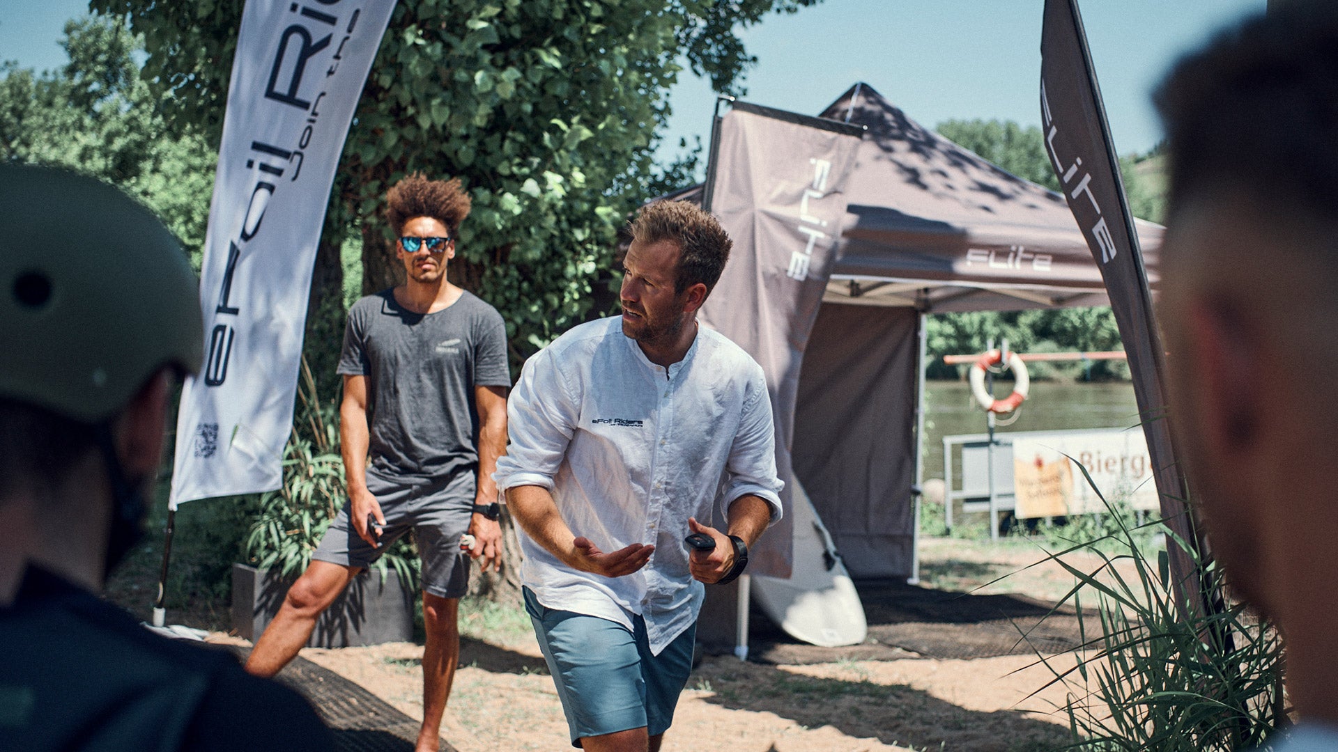 A surf instructor shows the students in Würzburg how to stand on a fliteboard.