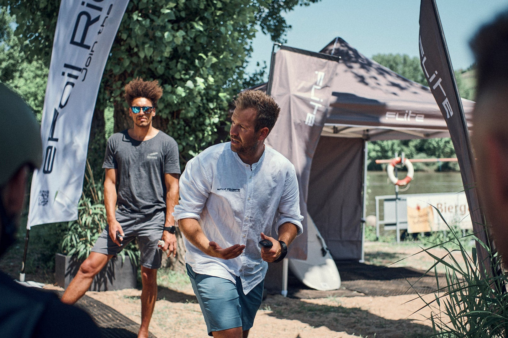 A surf instructor shows the students in Würzburg how to stand on a fliteboard.