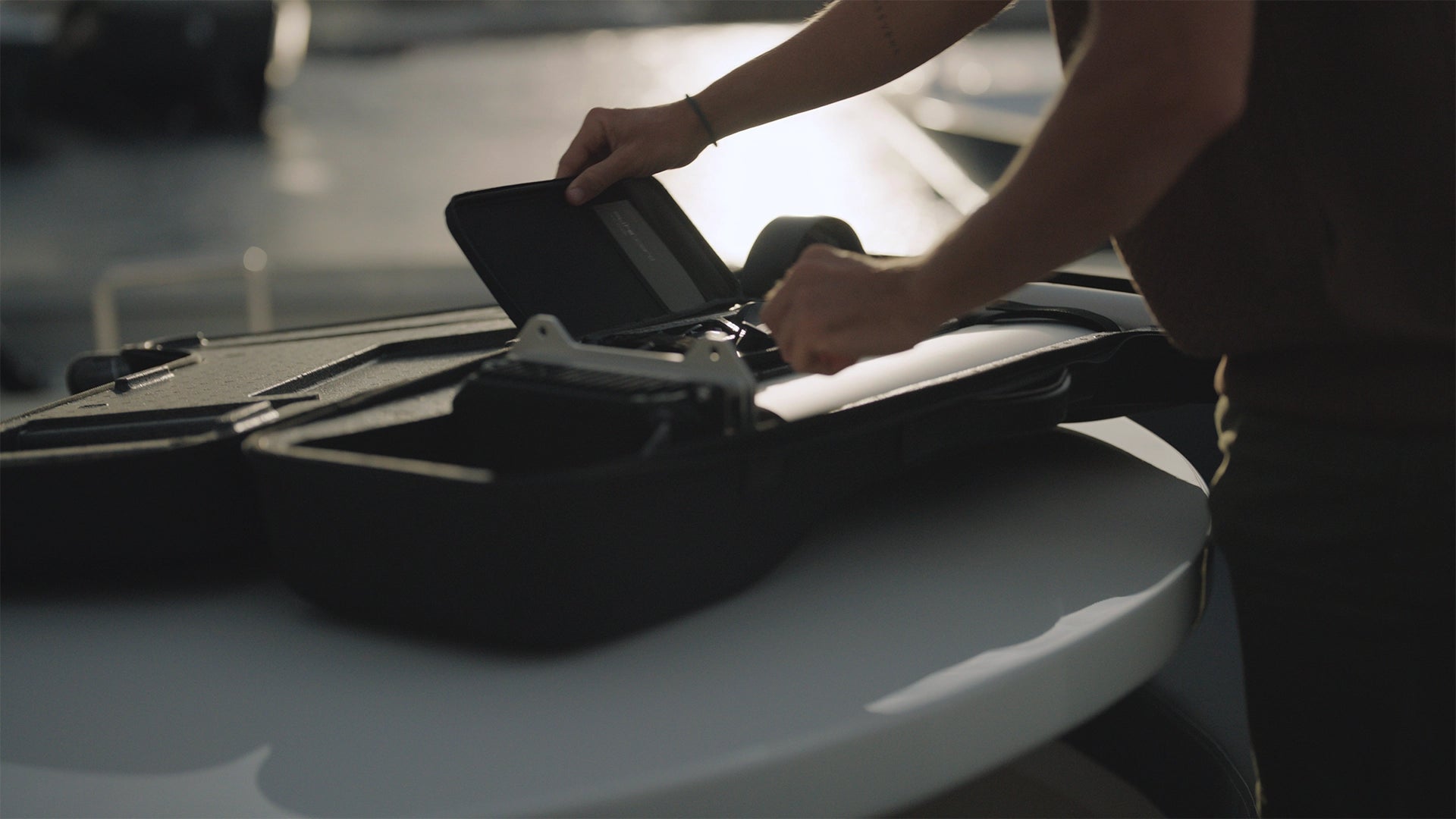 A man opens a Flite case and performs maintenance on the eFoil.