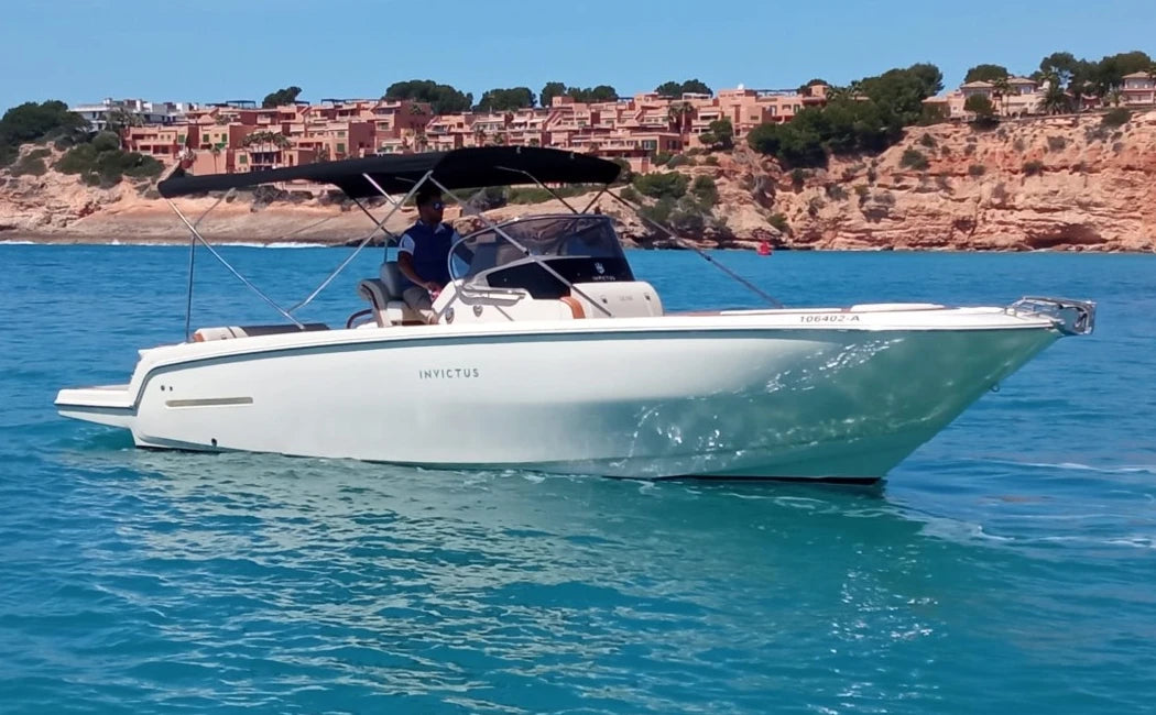 White boat on blue water with a scenic background