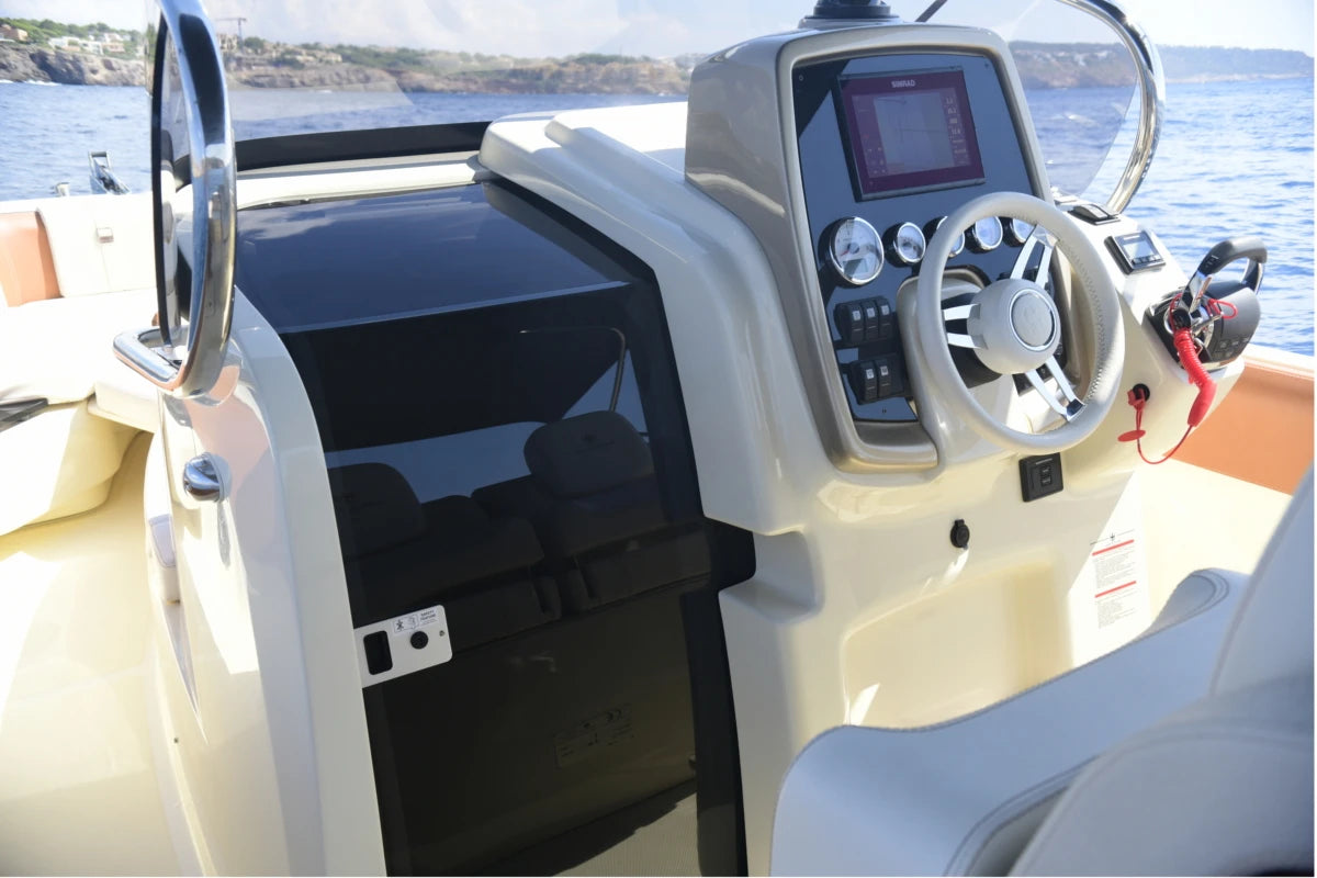 Boat dashboard with steering wheel and control panel on a body of water in Mallorca