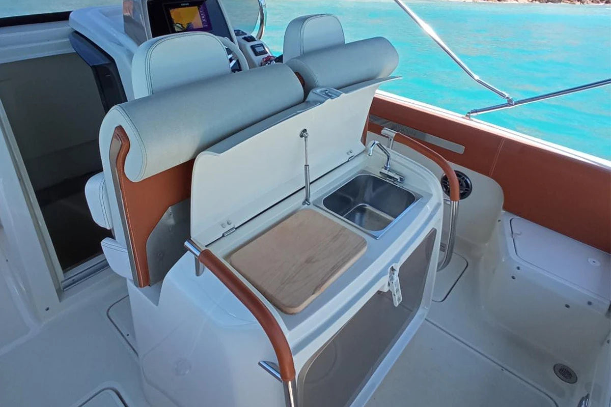 Interior of a boat with a sink and storage compartments.