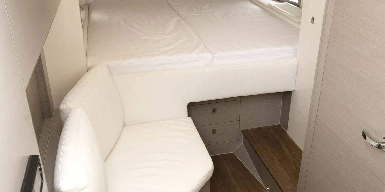 Interior of a Sinner boat with white upholstered seats and wooden floor.