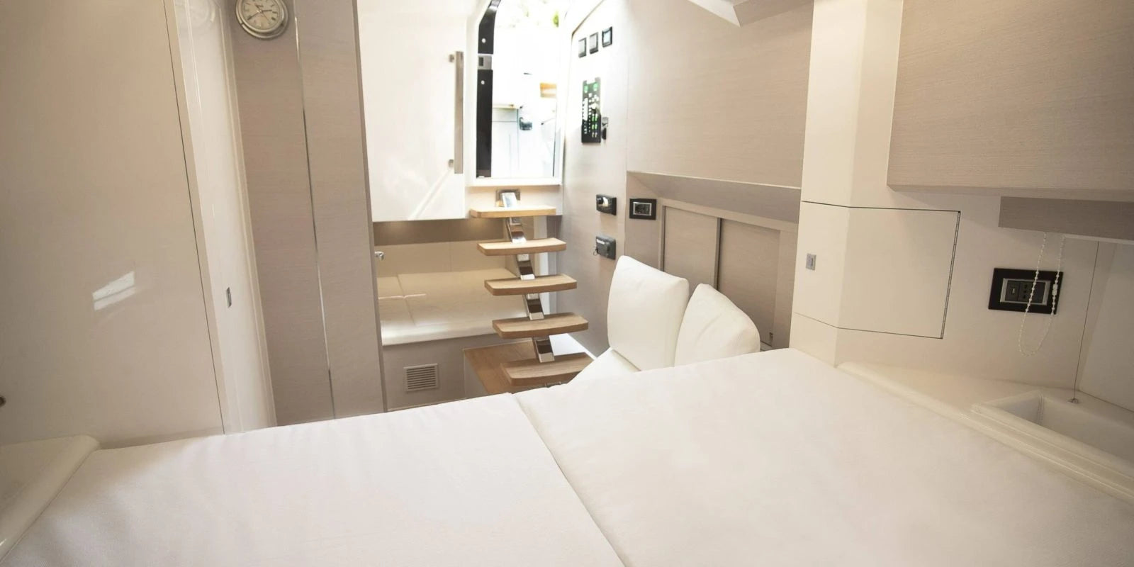 Modern bedroom in a sinner boat with a bed and a small kitchenette area.
