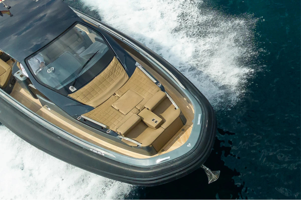 A black sinner boat with brown leather interior moving through the ocean.