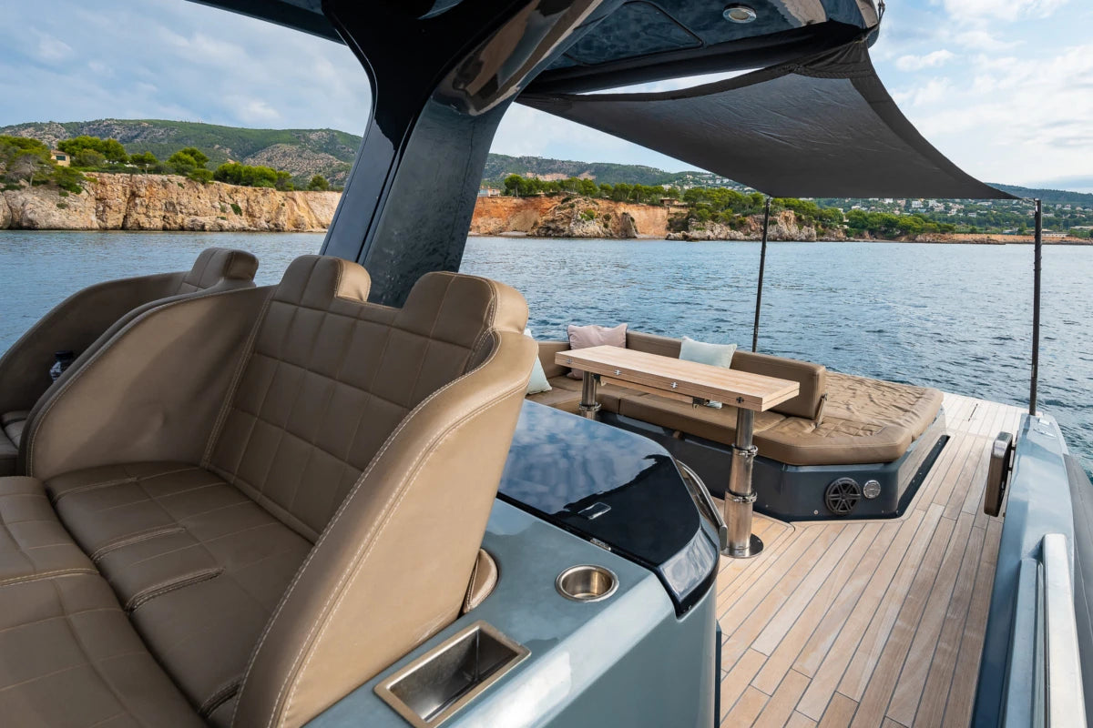 Interior of a sinner boat with seating area and table on a body of water in Mallorca.