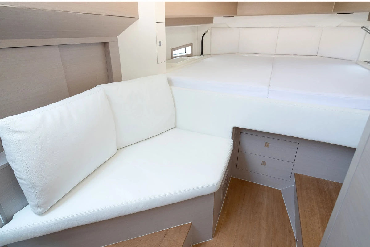 White upholstered seating area with wooden floor in a sinner boat interior.