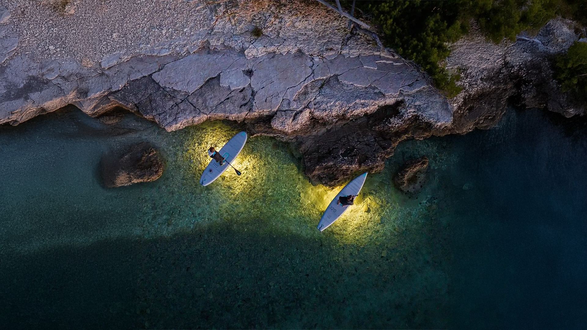 The picture shows a bird's eye view of two Sipa boards with people on them and the light shining below.