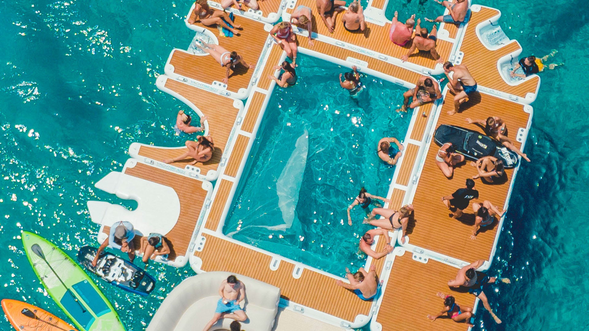 The Yacht Beach Jet Ski Single Version is fixed to other platforms, and people are sitting on them in the water.