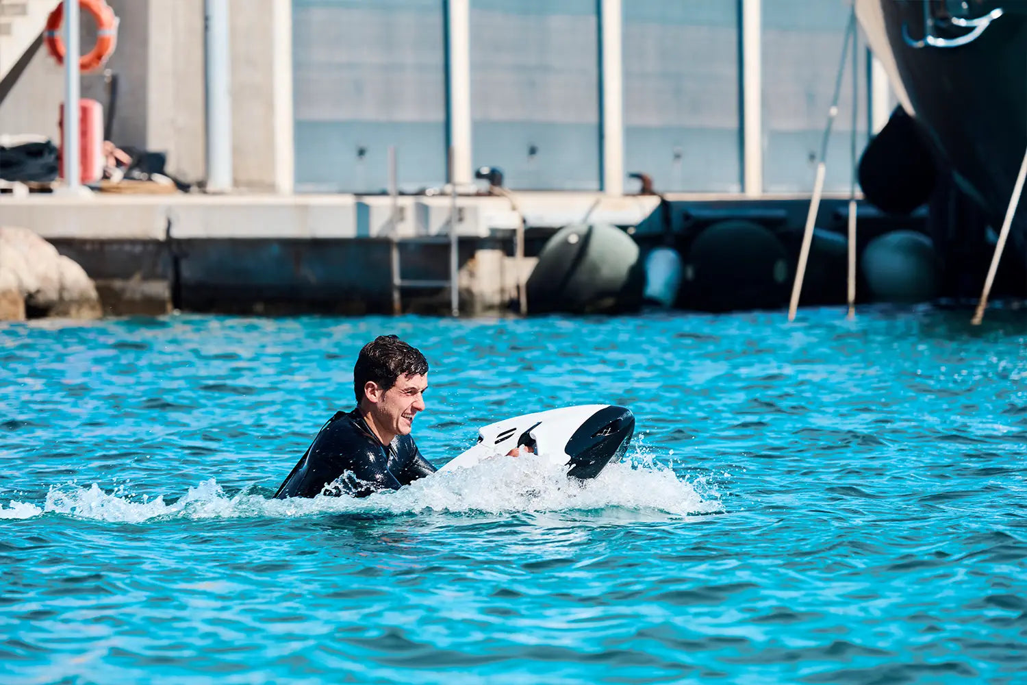 A man smiles as he rides a white Seabob on the sea in Mallorca.