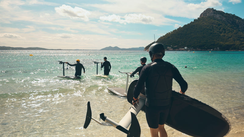 Four people go into the sea fully equipped with their Flitebaords.