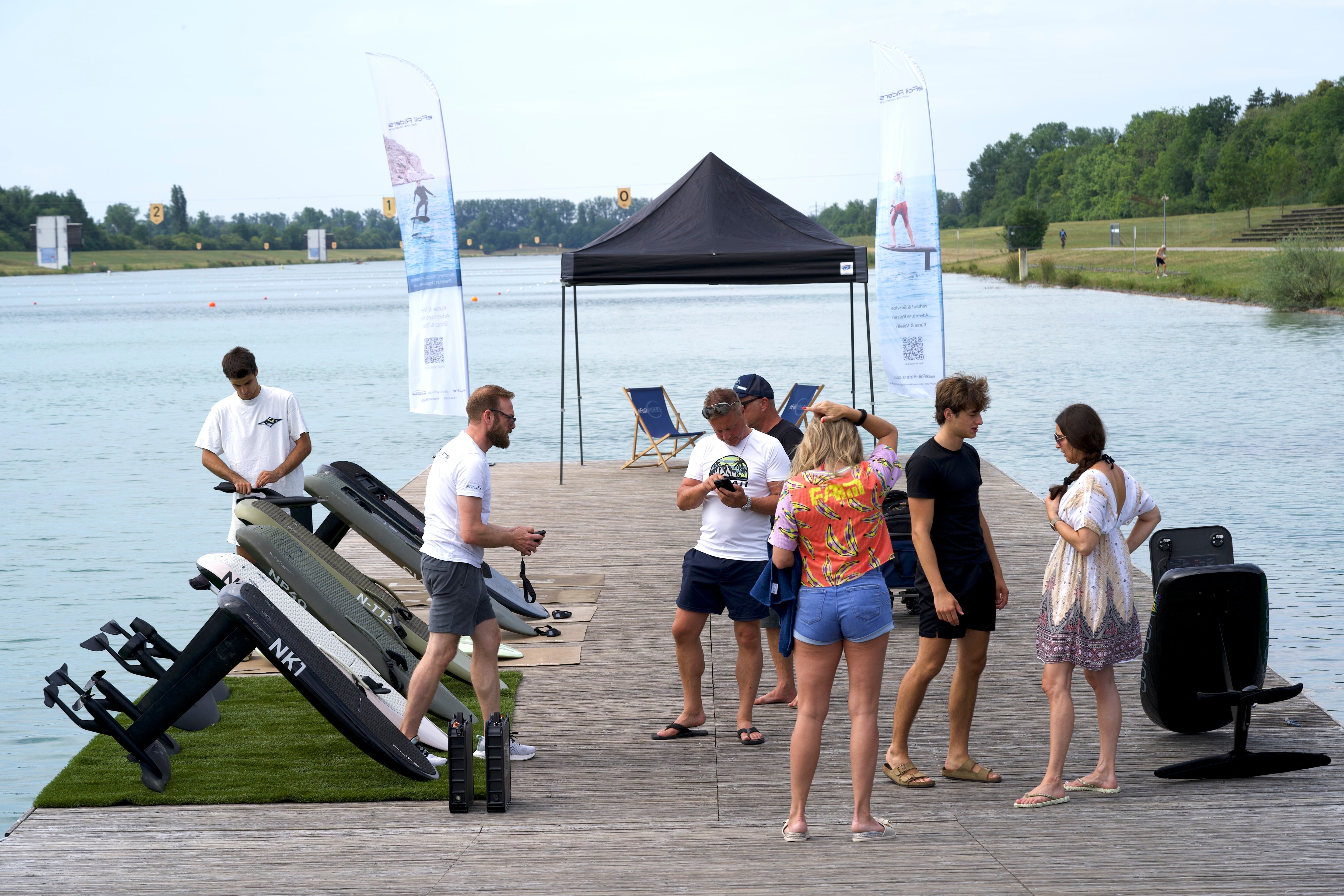 eFoil -Veranstaltung auf der Regattastrecke in München, bei der mehrere Personen sich darauf vorbereiten, ein Fliteboard zu benutzen.
